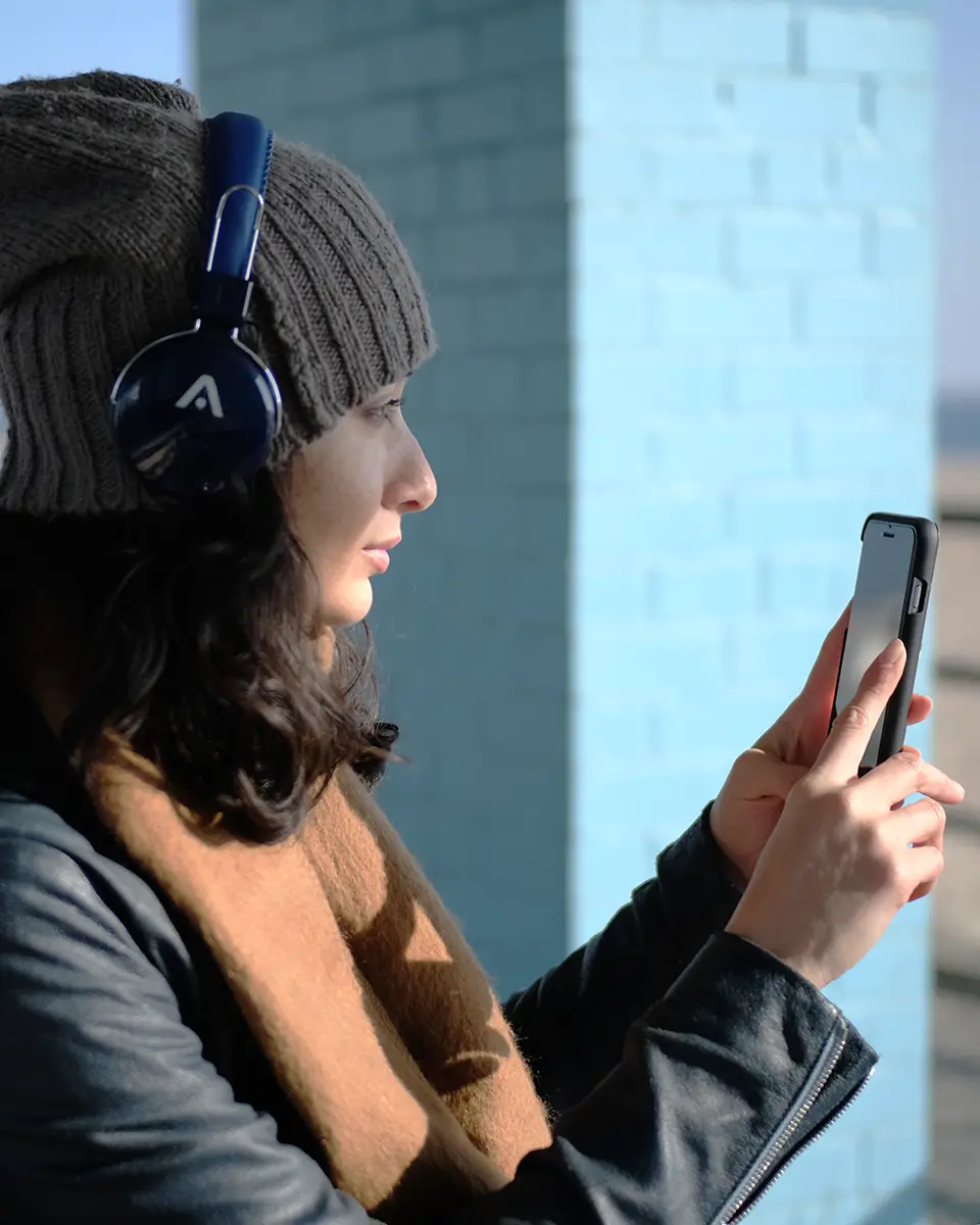 Lifestyle photography of wireless Bluetooth headphones worn outdoors for an audio brand